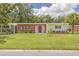 Charming single-story home with red brick accents, a spacious lawn, and mature landscaping at 505 Broxburn Ave, Temple Terrace, FL 33617