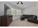 Modern living room with wood-look floors, a large window, ceiling fan, and plenty of space to relax at 505 Broxburn Ave, Temple Terrace, FL 33617