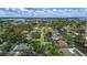 An aerial view that showcases the neighborhood with mature trees, waterfront, and the ocean in the distance at 5285 Dover Ne St, St Petersburg, FL 33703