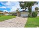 Charming home boasts beautiful paver driveway, a well-kept lawn, and lush landscaping at 5285 Dover Ne St, St Petersburg, FL 33703
