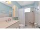 Bright bathroom featuring blue walls, a vanity with sink, and a shower with curtain at 6025 Shore S Blvd # 408, Gulfport, FL 33707