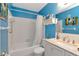 Well-lit bathroom with bright blue walls, tub and shower combination, and marble countertop at 6025 Shore S Blvd # 408, Gulfport, FL 33707