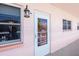 Exterior of a unit's front door with windows and a lantern-style light fixture at 6025 Shore S Blvd # 408, Gulfport, FL 33707