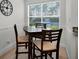 Cozy eat-in dining area featuring a wooden table, three chairs and a large window for natural light at 6080 Bahia Del Mar Cir # 109, St Petersburg, FL 33715