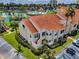 Beautiful exterior showcasing the terracotta roof, lush landscaping, assigned parking, and the nearby lake at 6080 Bahia Del Mar Cir # 109, St Petersburg, FL 33715
