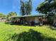 A backyard with a covered patio, lush green lawn, and a mix of trees and shrubs at 6326 38Th N Ave, St Petersburg, FL 33710