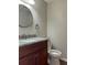 Cozy bathroom with granite countertop vanity, round mirror and white toilet at 6383 Biscayne, North Port, FL 34287