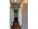 Long hallway with wood-look tile leads to bedrooms and bathrooms at 6383 Biscayne, North Port, FL 34287
