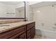 Bathroom featuring a brown vanity with granite countertop and a shower-tub combination with tile surround at 7021 Blossom Ave, Tampa, FL 33614
