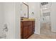 A bathroom vanity has granite countertops, brown cabinets, a mirror, and white tiled walls at 7021 Blossom Ave, Tampa, FL 33614