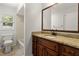 A full bathroom with a tiled tub and brown vanity with a white sink and granite countertop at 7021 Blossom Ave, Tampa, FL 33614