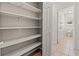 Walk-in closet with built-in shelving and convenient access to an adjacent bathroom at 7021 Blossom Ave, Tampa, FL 33614
