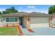 Charming single-story home featuring stone accents, a two-car garage, and a well-manicured lawn at 7021 Blossom Ave, Tampa, FL 33614