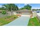 Beautiful single-story home featuring a two-car garage and manicured front yard with tropical palms at 7021 Blossom Ave, Tampa, FL 33614