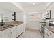Bright kitchen with stainless steel appliances, granite countertops, and white cabinets at 7021 Blossom Ave, Tampa, FL 33614