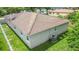 Tan home with a brown roof, central AC, white trim and fenced in yard with green grass at 7021 Blossom Ave, Tampa, FL 33614