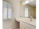 Bright bathroom features vanity area with sink and a large window overlooking the backyard at 7061 Denmark St, Englewood, FL 34224