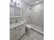 Bathroom features a vanity with marble countertop and a marble tiled shower at 8017 Tudor Pl, Tampa, FL 33610