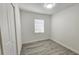 Empty bedroom with neutral walls, gray wood floor, and natural lighting at 8017 Tudor Pl, Tampa, FL 33610