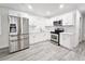 Modern kitchen featuring stainless steel appliances, white cabinetry, and wood-look flooring at 8017 Tudor Pl, Tampa, FL 33610