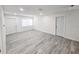 Well lit living room with gray flooring, white doors, and baseboards at 8017 Tudor Pl, Tampa, FL 33610