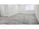 Bright living room featuring gray wood floors, white walls, window, and baseboards at 8017 Tudor Pl, Tampa, FL 33610