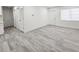 Bright living room with gray wood floors, recessed lighting, and white doors and trim at 8017 Tudor Pl, Tampa, FL 33610