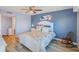 This bedroom features beachy accents, light blue walls, luxury vinyl plank flooring and a white queen bed at 8211 Brent St # 815, Port Richey, FL 34668
