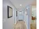 Bright hallway with wood-look flooring, decorative artwork, and a view into the adjacent living spaces at 8211 Brent St # 815, Port Richey, FL 34668