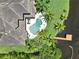 Stunning aerial perspective of a backyard oasis featuring a sparkling pool, lush greenery, and waterfront access with a private dock at 8707 Silverthorn Rd, Seminole, FL 33777