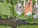 Luxury home aerial with a dock, a pool, lush landscaping, and waterway access at 8707 Silverthorn Rd, Seminole, FL 33777