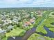 Wide aerial view of a community with homes, a golf course, and a waterfront in the neighborhood at 8707 Silverthorn Rd, Seminole, FL 33777