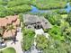 An aerial view of a luxury home with great curb appeal, an extensive driveway, and mature trees at 8707 Silverthorn Rd, Seminole, FL 33777