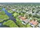 Expansive aerial view of homes in the area, lush greenery, and a waterfront in the neighborhood at 8707 Silverthorn Rd, Seminole, FL 33777