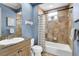 Cozy bathroom featuring a granite vanity, tub with shower, and decorative tile work at 8707 Silverthorn Rd, Seminole, FL 33777