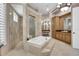 A luxurious bathroom suite with a large soaking tub, walk-in shower, and vanity area at 8707 Silverthorn Rd, Seminole, FL 33777