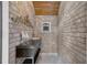Charming hallway with brick walls, accent furniture, and unique decor accents at 8707 Silverthorn Rd, Seminole, FL 33777