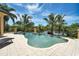 Inviting pool with waterfront views and lush palm trees, perfect for relaxation and entertainment at 8707 Silverthorn Rd, Seminole, FL 33777