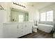 Stylish bathroom with a double vanity, stand alone tub, decorative accent wall, and a shower enclosure at 9110 Lantern Oak Way, Land O Lakes, FL 34638