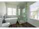 Bright bathroom features a soaking tub, walk-in shower, and wood-look floors at 9110 Lantern Oak Way, Land O Lakes, FL 34638