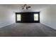 Large carpeted bedroom with a decorative accent wall, a ceiling fan, and windows with natural light at 9110 Lantern Oak Way, Land O Lakes, FL 34638