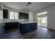 Modern kitchen with island, dark cabinets, stainless appliances, and sliding glass doors at 9110 Lantern Oak Way, Land O Lakes, FL 34638