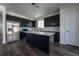 Well-lit kitchen boasts a large island, stainless steel appliances, and sleek, dark cabinetry at 9110 Lantern Oak Way, Land O Lakes, FL 34638