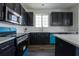 Well-lit kitchen showcasing dark cabinetry, stainless appliances, and ample counter space at 9110 Lantern Oak Way, Land O Lakes, FL 34638