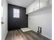 Laundry room with decorative black accent wall and storage at 9110 Lantern Oak Way, Land O Lakes, FL 34638