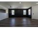 Open-concept living room with black accent wall, hardwood floors, and bright windows at 9110 Lantern Oak Way, Land O Lakes, FL 34638