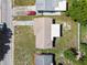 An aerial view shows the roof, the driveway with red car, and some of the property's lawn and landscaping at 10831 Manchester Rd, Port Richey, FL 34668