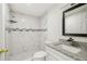 Bathroom featuring modern tiling, a framed mirror, and walk in shower at 10831 Manchester Rd, Port Richey, FL 34668