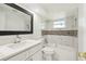 Bathroom featuring modern tiling, a framed mirror, and combined tub and shower at 10831 Manchester Rd, Port Richey, FL 34668