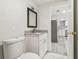 Bathroom featuring a marble vanity, framed mirror, and a kitchen in the background at 10831 Manchester Rd, Port Richey, FL 34668